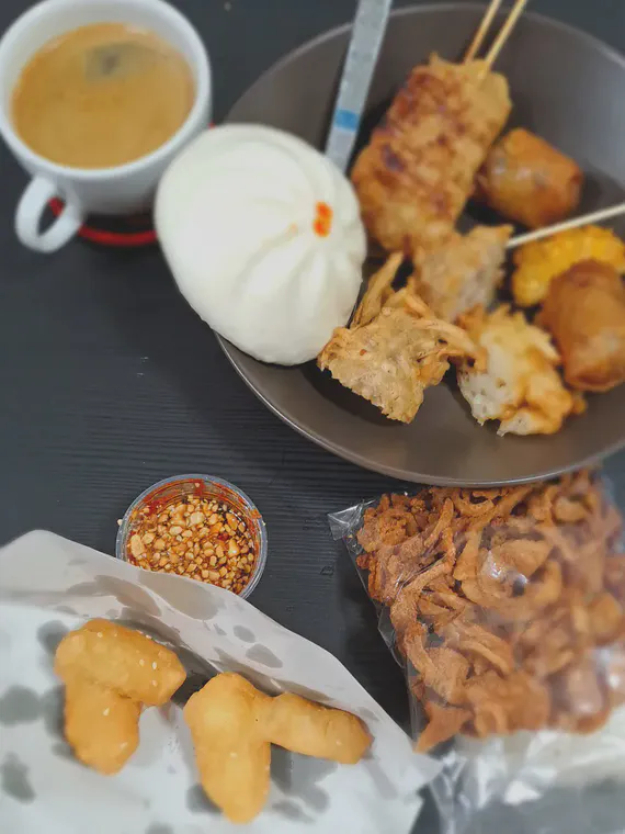 Fried dough, a steamed bun, fried tofu and spring roll and taro, *moo ping*, some crispy pork, sticky rice.